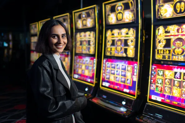 Uma mulher sorrindo enquanto joga online em seu laptop, cercada por elementos de cassino em néon, destacando a coleção diversificada de jogos do POPBR.